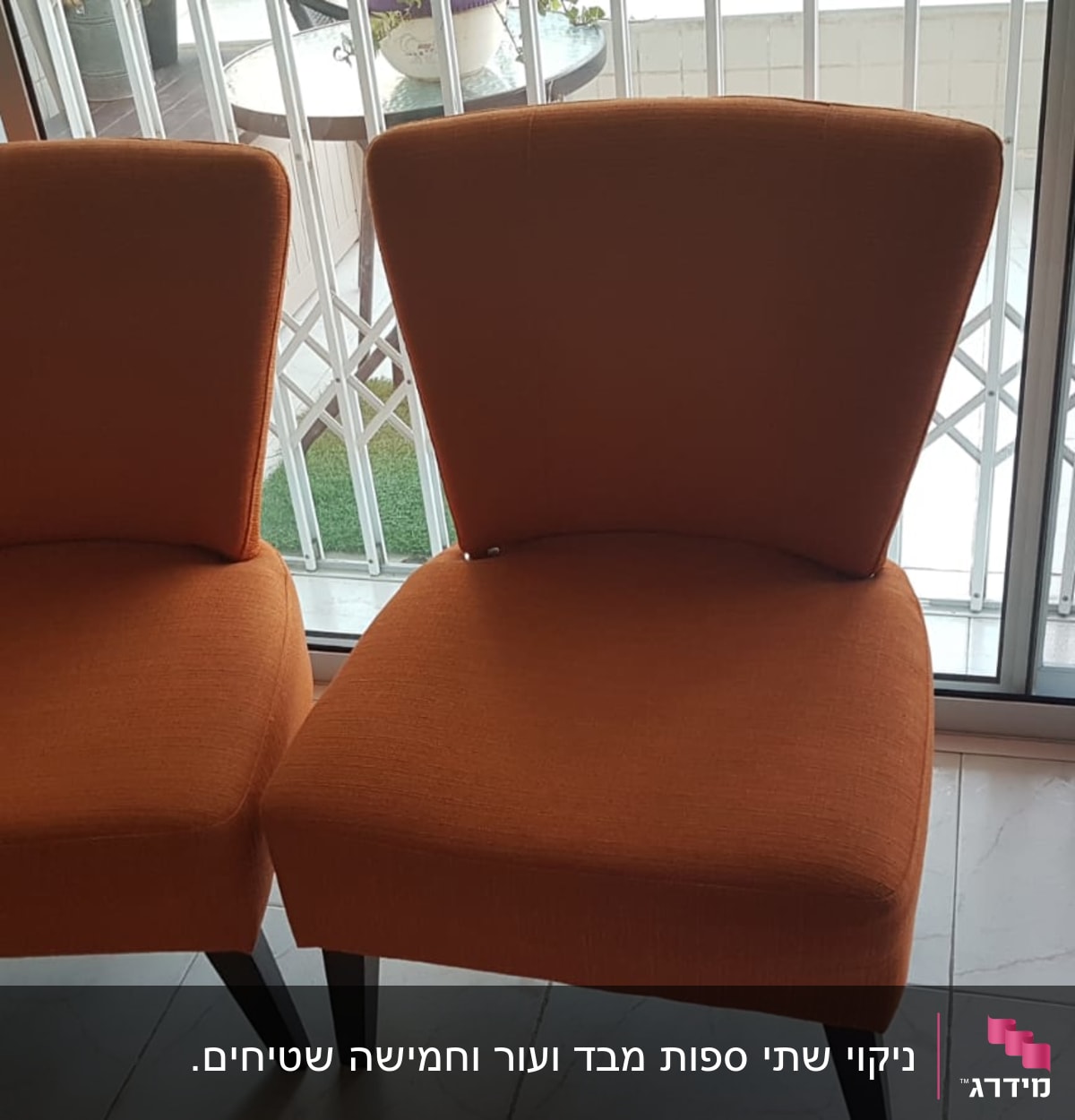 שני כיסאות כתומים ליד חלון זכוכית